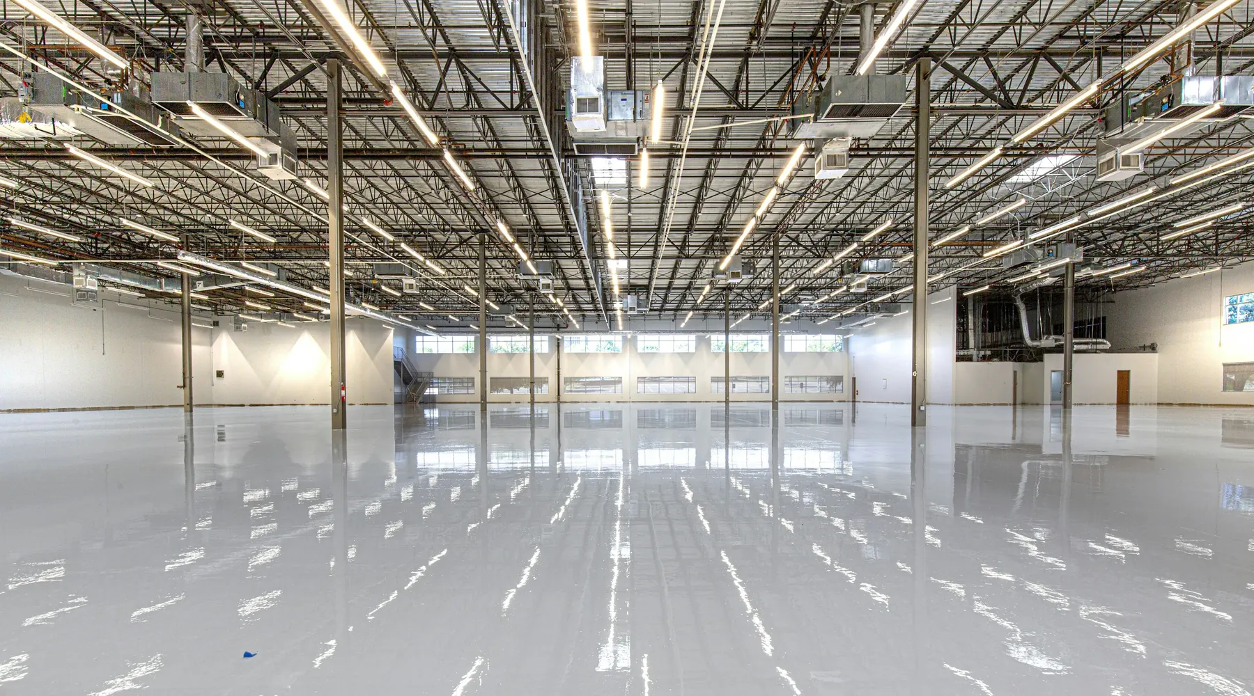 Interior de un galpón vacío con piso de hormigón brillante